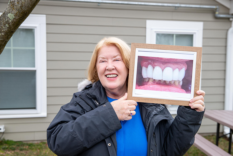 Dr. Gamburg's patient holding up her before photo